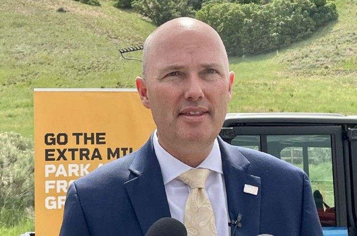 Governor Spencer Cox speaking at the 2023 Fire Sense kickoff event with grassy mountains in the background, June 6, 2023.